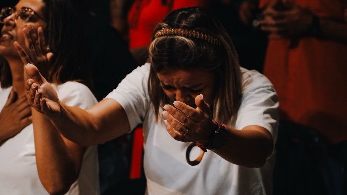 Mulheres em oração durante o culto